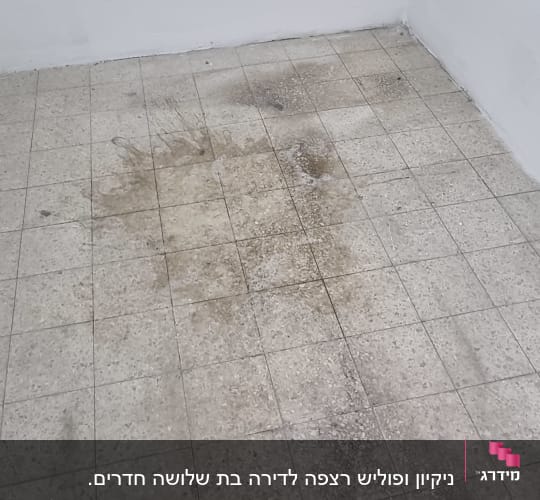 רצפה מלוכלכת עם כתמים כהים שזקוקה לניקוי